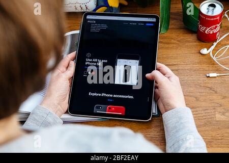 Paris, France - 16 avril 2020: Utilisez ar pour voir un nouvel iPhone - Femme regardant sur le site Internet d'Apple Computers sur la tablette iPad Pro dans l'environnement de la salle présentant le nouvel iPhone se Banque D'Images