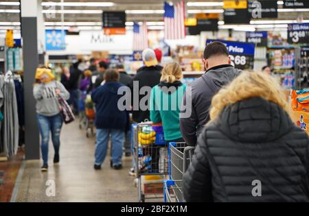 Cromwell, CT / USA - 20 mars 2020: Perple attendre dans de longues lignes pour un blanc (se concentrer sur l'homme avec sweat-shirt gris) Banque D'Images