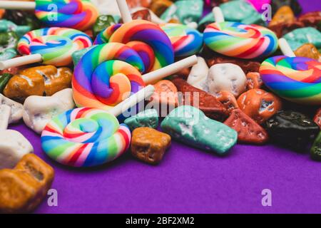 Sucettes et bonbons. Bonbons sous forme de pierres colorées. Fond coloré avec bonbons colorés. Décoration festive Banque D'Images