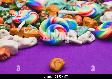 Sucettes et bonbons. Bonbons sous forme de pierres colorées. Fond coloré avec bonbons colorés. Décoration festive Banque D'Images