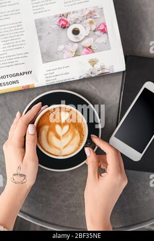 Femme buvant un cappuccino savoureux dans un café