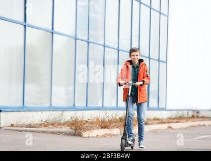 Adolescent à cheval kick scooter dehors Banque D'Images