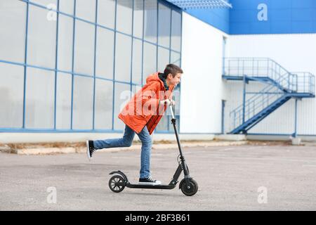 Adolescent à cheval kick scooter dehors Banque D'Images