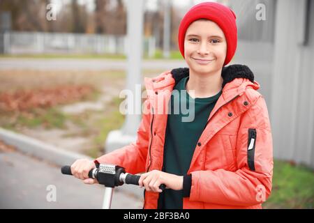 Adolescent à cheval kick scooter dehors Banque D'Images