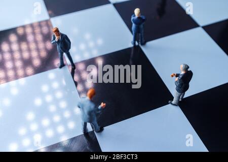 Les hommes d'affaires miniatures pratiquant la distanciation sociale pour ralentir la propagation du coronavirus mortel Banque D'Images