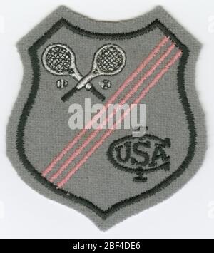 Patch pour le International Lawn tennis Club des États-Unis. Patch gris en forme de bouclier. En haut à droite du quadrant inférieur gauche, trois (3) lignes diagonales étroites sont en rose. Dans le coin supérieur gauche se trouve une paire de raquettes de tennis croisées avec deux (2) balles de tennis. Banque D'Images