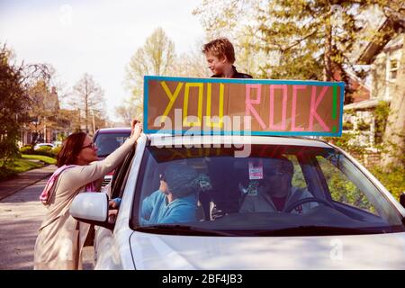 Bloomington, États-Unis. 16 avril 2020. Mary Alice Rickert, à gauche, réagit à un élève pendant la parade.les élèves de la 4ème classe de Mary Alice Rickert à l'école primaire Childs, tiennent un défilé surprise de distanciation sociale pour lui dire qu'ils lui manquent. Rickert a enseigné aux étudiants virtuellement, mais a dit qu'elle s'est rendue compte, les étudiants sont la seule raison qu'elle enseigne, et elle les manque. Elle a dit que le défilé est l'une des plus belles choses que personne n'a jamais fait pour elle. Crédit: SOPA Images Limited/Alay Live News Banque D'Images