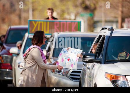 Bloomington, États-Unis. 16 avril 2020. Un élève donne un placarde à Mary Alice Rickert, laissée pendant la parade.les élèves de la quatrième classe de Mary Alice Rickert à l'école primaire Childs, tiennent un défilé surprise de distanciation sociale pour lui dire qu'ils lui manquent. Rickert a enseigné aux étudiants virtuellement, mais a dit qu'elle s'est rendue compte, les étudiants sont la seule raison qu'elle enseigne, et elle les manque. Elle a dit que le défilé est l'une des plus belles choses que personne n'a jamais fait pour elle. Crédit: SOPA Images Limited/Alay Live News Banque D'Images