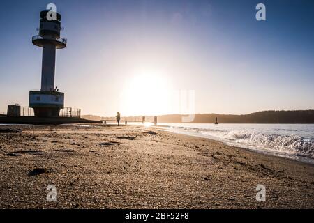 Kiel, Allemagne. 17 avril 2020. Une femme se tient au lever du soleil devant le phare de Friedrichsort, dans le fjord de Kiel. Crédit: Frank Molter/dpa/Alay Live News Banque D'Images