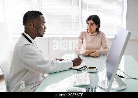 Médecin discutant avec un patient féminin en clinique Banque D'Images