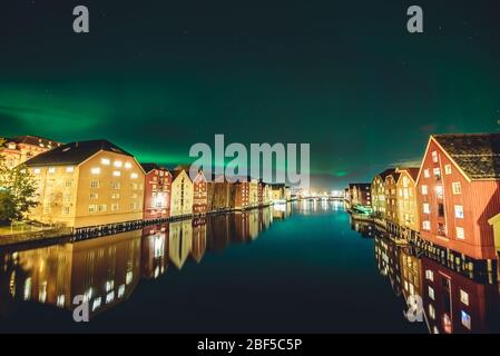 Les aurores boréales (aurores boréales) sont actives dans le quartier de Bakklandet, au centre de Trondheim, dans le nord de la Norvège. Banque D'Images