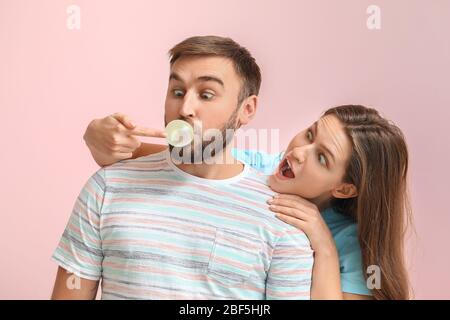 Drôle de jeune couple avec chewing-gum sur fond de couleur Banque D'Images