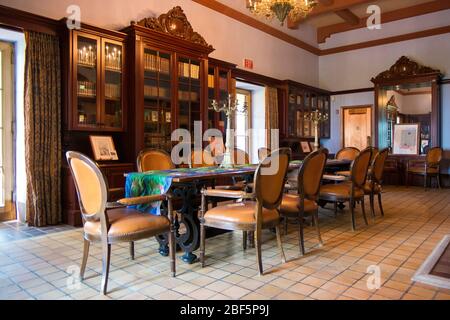 Vue sur la salle à manger avec de grandes librairies en bois dans le manoir en pierre. Au parc national du patrimoine de Charles Deering Estate à Miami, en Floride. Banque D'Images