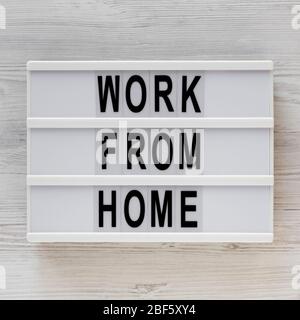 Mots « travailler à domicile » sur une visionneuse sur une surface en bois blanc, vue de dessus. En hauteur, par dessus, plat. Banque D'Images