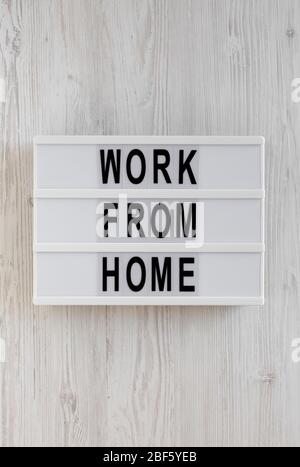« travailler à domicile » sur une visionneuse sur fond blanc en bois, vue de dessus. En hauteur, par dessus, plat. Banque D'Images