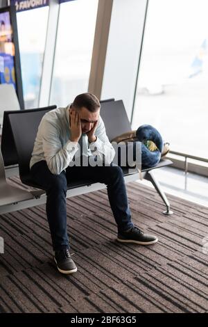 Voyageur à l'aéroport d'attente déprimé après les retards et annulations de vols Banque D'Images