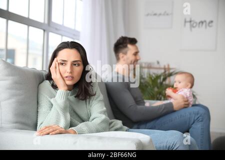 Heureux père avec son bébé et sa femme souffrant de dépression postnatale à la maison Banque D'Images