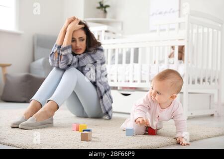 Jeune femme souffrant de dépression postnatale à la maison Banque D'Images