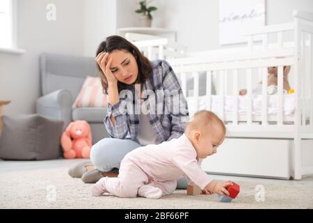 Jeune femme souffrant de dépression postnatale à la maison Banque D'Images