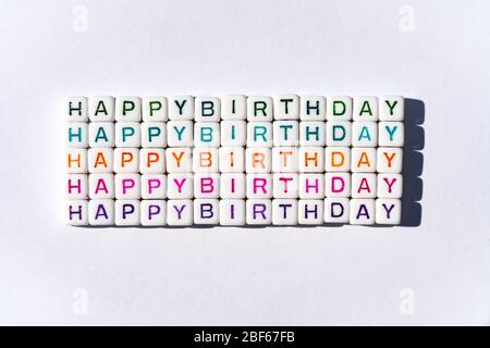 Carte postale d'anniversaire joyeuse avec cubes multicolores sur fond blanc Banque D'Images