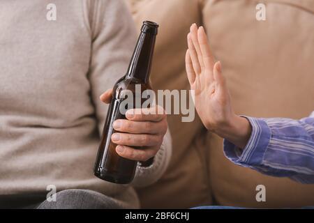 Femme refusant de boire de la bière à la maison. Concept d'alcoolisme Banque D'Images