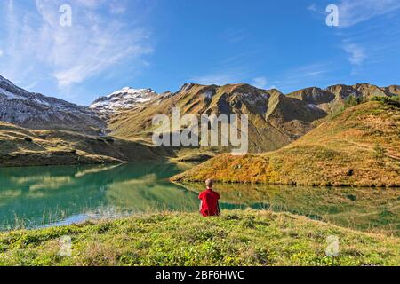 Homme assis sur un lac de montagne. Alpes d'Allgäu, Bavière, Allemagne Banque D'Images