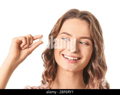 Jeune femme avec de l'huile de poisson sur fond blanc Banque D'Images