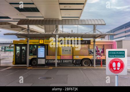 tokyo, japon - 16 avril 2020: Panneau de distanciation sociale à l'arrêt de bus dans le terminal 3 de l'aéroport international de Narita avec une navette décorée avec t Banque D'Images