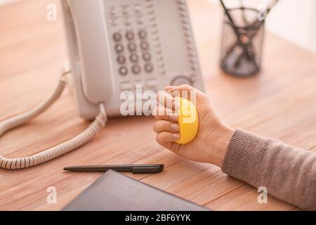 Une femme qui appuie sur le ballon de stress tout en travaillant au bureau Banque D'Images