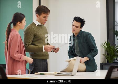 Groupe de personnes en affaires qui planifient le travail en équipe à la table et lisent les documents au bureau Banque D'Images
