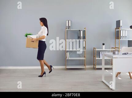 Une femme chômeur rejetée avec une boîte en carton dans le bureau quitte à la recherche d'un nouvel emploi. Banque D'Images