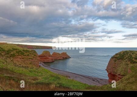 Les falaises des trois Sœurs s'étendant dans la mer du Nord depuis Cove Haven Bay sur le sentier côtier d'Arbroath lors d'une journée calme dans les octobères. Banque D'Images