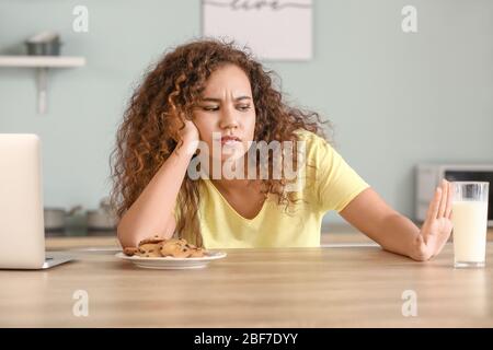 Femme afro-américaine allergique aux produits laitiers dans la cuisine Banque D'Images