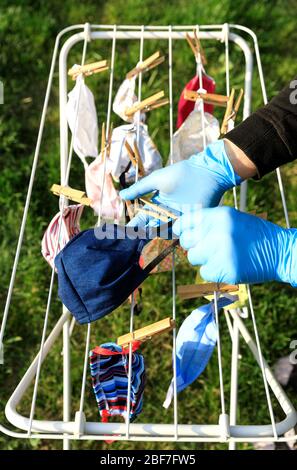 Masque de séchage suspendu sous le soleil après utilisation pour la désinfection. Masque hygiénique suspendu sur le rack extérieur après lavage pour la propreté et l'hygiène d Banque D'Images