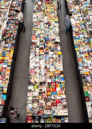 Marché intérieur de livres. Vue panoramique sur un groupe de clients qui parcouraient les étals d'un marché intérieur de livres. Banque D'Images