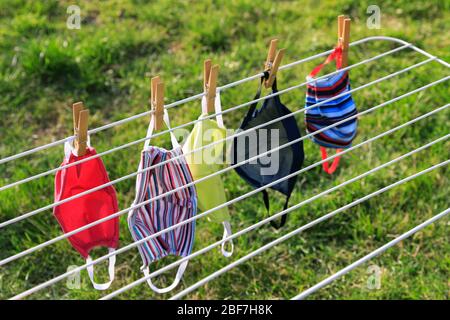 Masque de séchage suspendu sous le soleil après utilisation pour la désinfection. Masque hygiénique suspendu sur le rack extérieur après lavage pour la propreté et l'hygiène d Banque D'Images