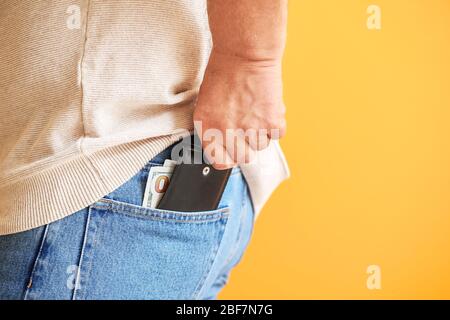 Homme senior avec sac à main sur fond de couleur, gros plan Banque D'Images