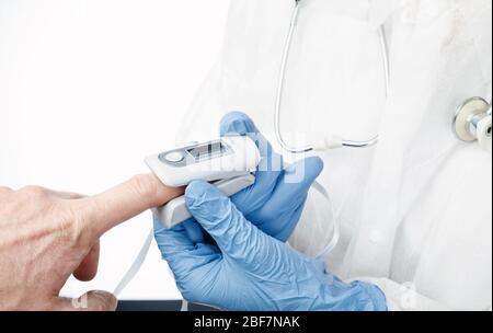 Gros plan du médecin utilisant l'oxymètre de pouls pour vérifier la saturation en oxygène et la fréquence cardiaque d'une personne qui suit les symptômes du coronavirus - épidémie de vir Banque D'Images