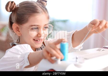 Mignonne petite couturière travaillant dans l'atelier Banque D'Images