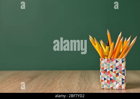 Jeu de crayons et de stylos sur la table près du tableau de bord de l'école Banque D'Images