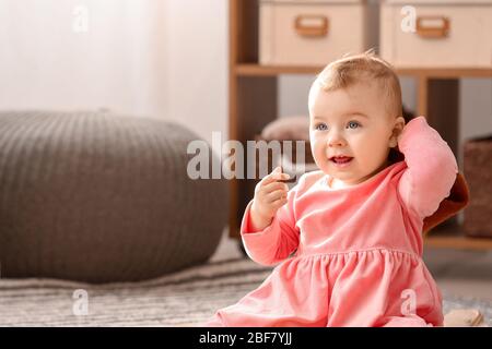 Jolie fille de bébé dans une robe élégante à la maison Banque D'Images