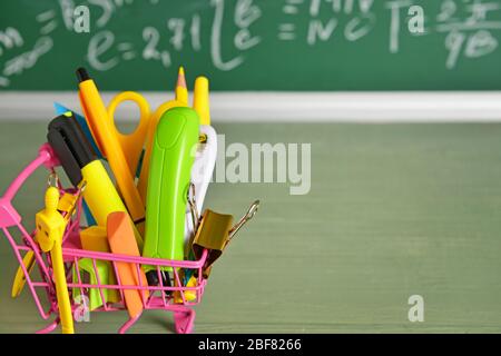 Panier avec fournitures scolaires sur table Banque D'Images