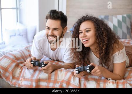 Un jeune couple heureux jouant à des jeux vidéo dans la chambre Banque D'Images