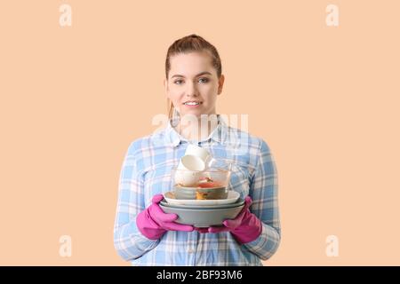 Femme avec des plats sales sur fond de couleur Banque D'Images