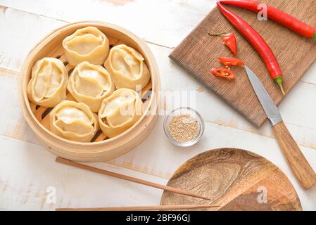 Cuiseur vapeur avec boulettes orientales et piment sur table Banque D'Images