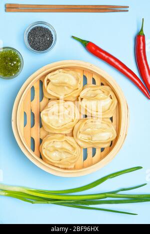 Cuiseur vapeur avec boulettes orientales et sauce sur fond couleur Banque D'Images