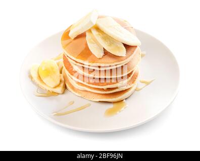 Crêpes savoureuses avec miel, beurre et banane sur fond blanc Banque D'Images