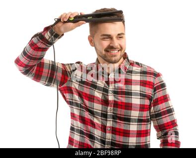 Beau jeune homme avec un fer à aplatir sur fond blanc Banque D'Images