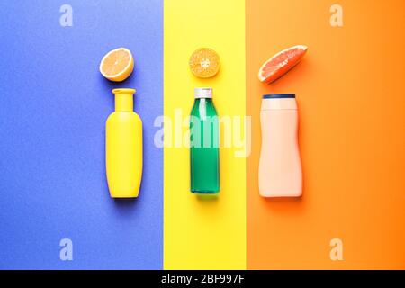 Bouteilles de shampooing et agrumes sur fond couleur Banque D'Images