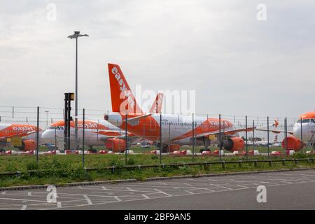 Southend-on-Sea, Royaume-Uni. 17 avril 2020. Plusieurs avions EasyJet stationnés derrière des clôtures de sécurité à l'aéroport de Londres Southend, Essex, Royaume-Uni. L’avion affiche la marque distinctive orange et blanche de la compagnie aérienne. Le ciel couvert et les barrières au sol contribuent à assombrir la scène aéroportuaire. Les avions easyJet sont assis sur la piste de l’aéroport de Southend à la suite des mesures prises par les États européens et les principales compagnies aériennes européennes, en réponse à la pandémie de COVID-19. Penelope Barritt/Alamy Live News Banque D'Images